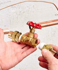 Hands holding Real Solid 3/4 Inch Brass Pipe Union Fittings Three Pack Copper To Male Thread Sweat Plumbing Connectors.