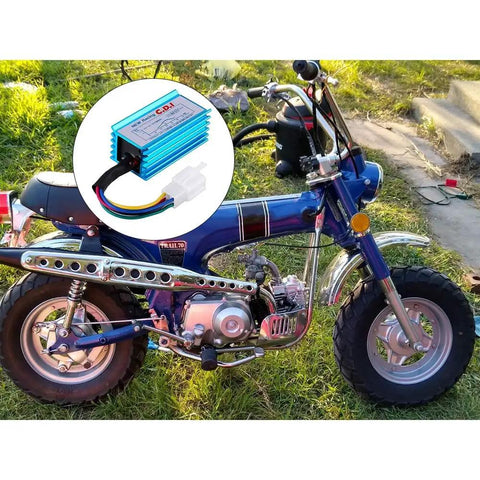 AC 5 Pin CDI Box For GY6 50cc To 160cc Engines with blue aluminum shell next to parked dirt bike on grass