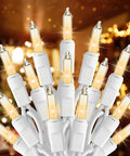 Clear Incandescent Mini Christmas Lights 100-Count On 20 Ft White Wire End-To-End Connectable 2.4 Inch Bulbs glowing indoors