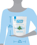 Person holding a bag of Muscle Recovery Epsom Salt Soak with Eucalyptus and Peppermint Essential Oils, dimensions shown.
