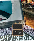 Tough Mud Color Outdoor Storage Box Shockproof All Purpose Case open near tent with flashlight inside, camping setup