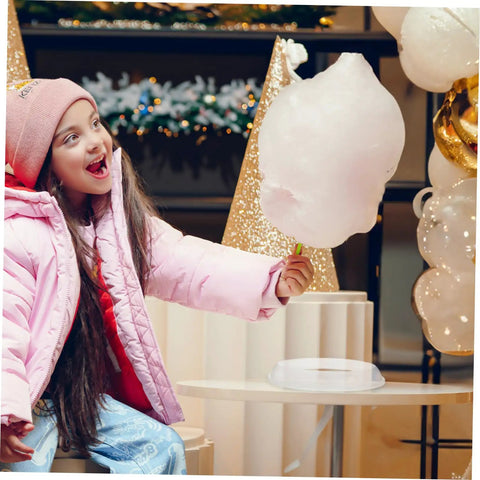 Child holding cotton candy next to Cotton Candy Machine Guard Cover For Sugar Floss Makers Lightweight And Reusable Enclosure Easy To Clean Indoor Use Mess Free Protection That Keeps Little Fingers Safe And Your Countertop Clean.
