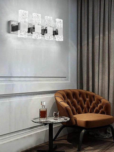 Modern LED Bathroom Vanity Light Fixtures Sleek Dope Chrome Stainless Steel Four Light Wall Sconces Over Mirror 28 Inch Dimmable 40W Crystal Cool White 5800K with Corrugated Crystal Design for Bright Elegant Bathroom Update, shown in a stylish room above a table.