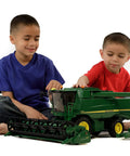Kids playing with John Deere T670i 1 To 16 Scale Combine Harvester Toy for indoor and outdoor play, detailed ABS plastic model.