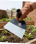 Heavy Duty Garden Hoe For Weeding With Steel Construction held over garden bed, ideal for soil loosening and weed control