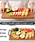 Person holding wooden cutting board with metal handles, topped with sliced fruits and avocados, demonstrating ease of use.