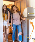 Two people entering a room; inset shows Spring Door Stoppers 12 Pack Wall Protectors For Inside Doors With 6 Rubber Bumpers Gold Finish Elastic Steel Spring Design Keeps Doors From Slamming Dents Ideal For Home And Office installed on the wall.