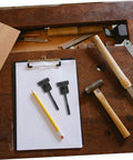 Spare Tire Hold Down Screw Kit for Honda Civic HR-V and multiple models on a clipboard with pencil and tools nearby.