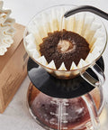 Large Flat Bottom Coffee Filters Tall Walled 9.75 Inch Wide 4.25 Inch Tall 2.75 Inch Sides 300 Count Compatible With BUNN And 12 Cup Home And Commercial Coffee Makers Durable Pulp Paper For Your Daily Cup Of Joe in a drip coffee brewer with water being poured over grounds.