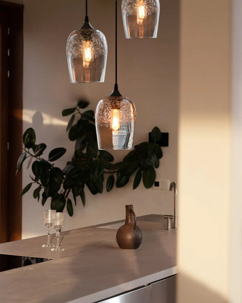 Three Light Teardrop Glass Pendant Chandelier With Hand Blown Seeded Bubbles over modern kitchen island at sunset.