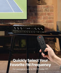 Image of Six Channel Home Theater Receiver With 1000W Peak Power, Bluetooth 5.3. A hand holds a remote in a living room setting.