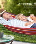 Couple relaxing in Durable 320G Canvas Camping Hammock With 550Lbs Capacity in a garden setting