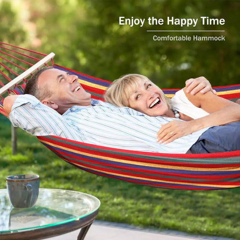 Couple relaxing in Durable 320G Canvas Camping Hammock With 550Lbs Capacity in a garden setting
