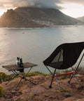 Ultralight Camping Table With Cup Holder And Carry Bag, Foldable Aluminum Backpacking Table set up on scenic hillside overlooking water