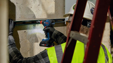 Worker using Two In One Cordless Impact Driver And Wrench 18V Connected Ready For One Fourth Inch And One Half Inch Bits And Sockets