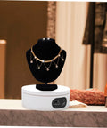 Luxshiny Electric Jewelry Rotating Turntable Display Stand showcasing a gold and crystal necklace on a black bust.