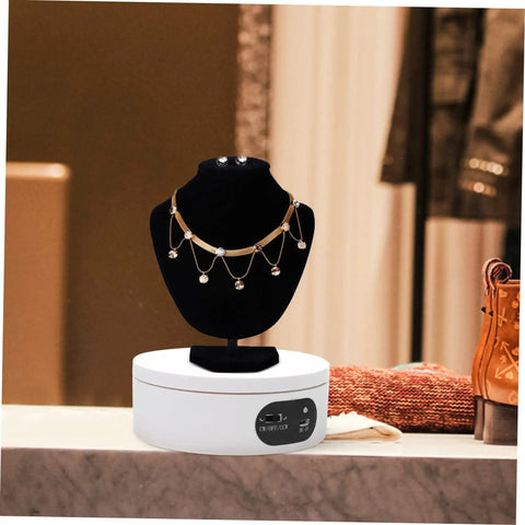 Luxshiny Electric Jewelry Rotating Turntable Display Stand showcasing a gold and crystal necklace on a black bust.