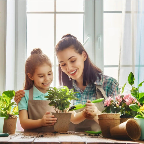 Mother and daughter gardening with Biodegradable Seedling Pots 120 Pack 3.15 Inch With 30 Plant Labels for germination in sunlight