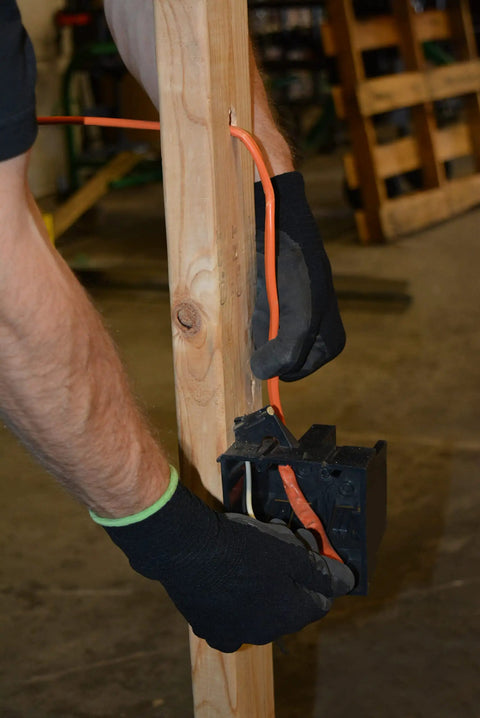Person installing 100 Foot 10/2 NM-B Romex Copper Wire With Ground For Dry Location Residential Wiring, SIMpull Jacket.
