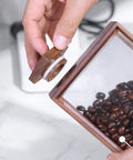 Handcrafted Solid Wood Coffee Bean Jar With Reliable One Way Degassing Valve And Heavy Duty Rubber Seal showing the lid being held.
