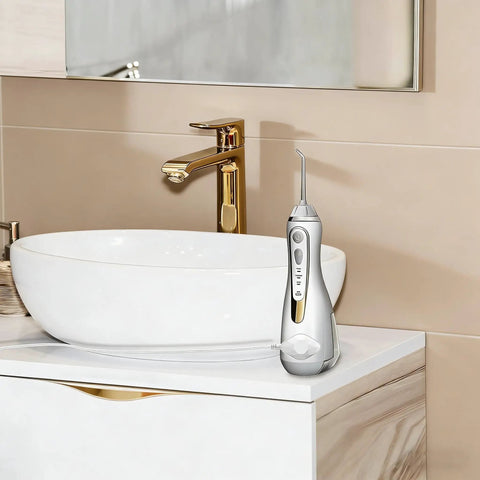 Cordless water flosser standing on bathroom sink counter next to faucet, no charger visible
