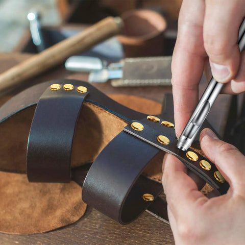 Close-up of a hand attaching 60 Pairs Solid Brass Chicago Screws For Belts And Jeans Including Heavy Duty Hole Punch Kit For Leather Straps And Clothing Repair on leather sandals.