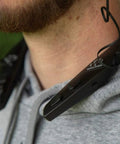 Close-up of person wearing Behind The Neck Bluetooth Hearing Enhancer For Hunters With Retractable Earbuds, rugged black design