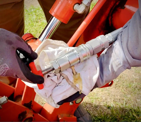 Hydraulic Quick Coupling Pressure Relief Tool For Half Inch Pioneer Ag Poppet Style Fittings in use on farm equipment.