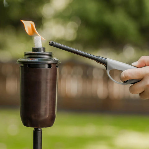 Lighting a honey copper outdoor tiki torch with 2-Pack Honey Copper Outdoor Torches For Patio Backyard And Garden No-Fuss Ready-To-Go Easy-Install Tiki Style Torches With Weather-Resistant Bronze Finish Includes Long-Lasting Wicks And Snuffer Safe And Stylish Ambiance focus keyword