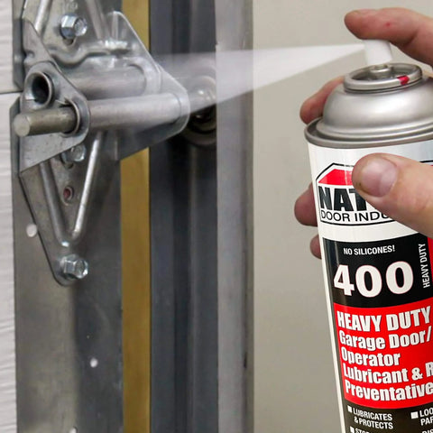 Applying Heavy Duty Garage Door Lubricant Spray With Rust Preventative And Long Lasting Hinge And Track Protection