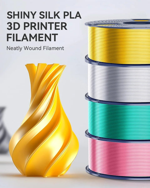 Front view of silk PLA filament spools in gold, silver, teal and pink beside a decorative gold sculpture.