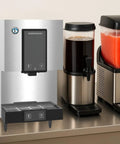 Straight Up Countertop Cubelet Ice Maker And Water Dispenser with sleek stainless steel design, located beside beverage dispensers.