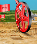 Distance Measuring Wheel With Marking Flags, 12 Inch Collapsible Design, red wheel on dirt surface with red flags.