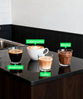 Four types of coffee drinks, labeled as American, Cappuccino, Latte, and Mocha, on a countertop.