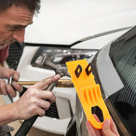 Professional Grade Paintless Dent Removal Kit featuring sturdy orange puller held by a person repairing a car panel.