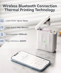 D110 Upgraded Mini Label Maker With Tape, Pocket Size Bluetooth Thermal Printer next to smartphone on table