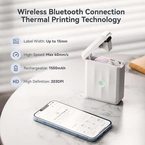 D110 Upgraded Mini Label Maker With Tape, Pocket Size Bluetooth Thermal Printer next to smartphone on table
