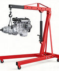 Heavy Duty Folding Hydraulic Engine Hoist Two Ton Portable Garage Cherry Picker lifting an engine, featuring a robust red frame and smooth casters.