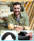Man wearing Ultra Comfy Noise Cancelling Ear Muffs For Adults And Kids 31dB Hearing Protection, holding tools, in workshop.