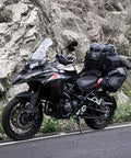 Expandable Motorcycle Tail Bag 60L Waterproof All Weather Travel Luggage For Trunk Rack With Sissy Bar Straps Rain Cover And Large Capacity From 40L To 60L Road Trip Ready Black mounted on a motorcycle parked by a rocky roadside