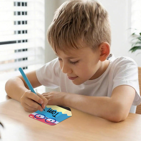 Child writing name on colorful 36 pack pencil desk name plates with waterproof PET film for classroom organization and student name tags