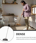 Dark Grey Angle Floor Broom With Long Stainless Steel Handle And Dense Stiff Bristles Snags Pet Hair Kitchen Messes And Daily Grime So Flipping Your Space Clean Is Total No Sweat Mode in use for cleaning debris.