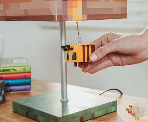Hand pulling 3D bee puller on Pixelated Yellow Bee Nest Block Desk Lamp With 3D Bee Puller And LED Mood Light For Bedroom Desk Playroom Pixel Gaming Decor For Kids Room Nightstand Accent That Is Totally Lit on wooden desk