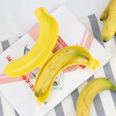 Reusable Banana Keeper Guard With Secure Snap Lid keeps bananas fresh inside yellow container on striped towel.
