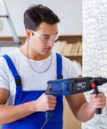 Man using drill wearing 60 Pairs Protective Safety Goggles With 60 Pairs Reusable Earplugs, Clear Anti Scratch UV Resistant Wraparound Eyewear