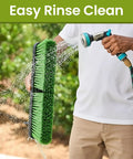 18 Inch Indoor Shop And Garage Push Broom With Soft Bristles being rinsed with a hose