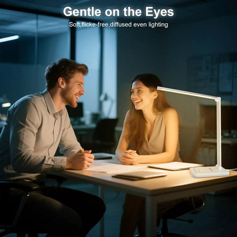Two people working at a desk illuminated by a Dimmable LED Desk Lamp with USB Port, 52 eye friendly LEDs and smart touch control