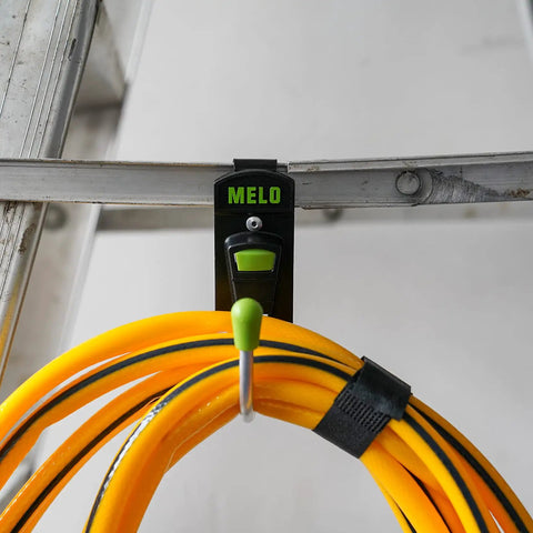 180 Degree Rotating Cordless Drill Holster Hook With Foldaway Design mounted on a ladder, holding yellow cord