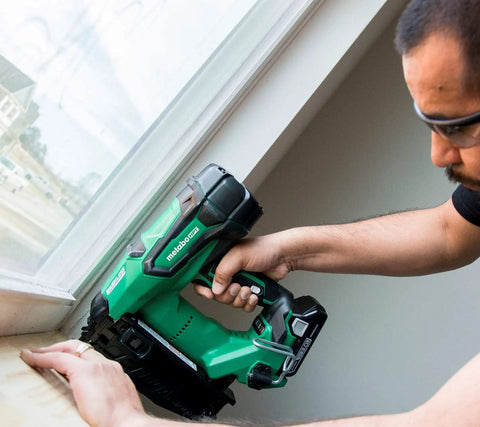 Person using Pro Grade 18V Brushless 16 Gauge Cordless Finish Nailer Kit with 3Ah Battery on window trim