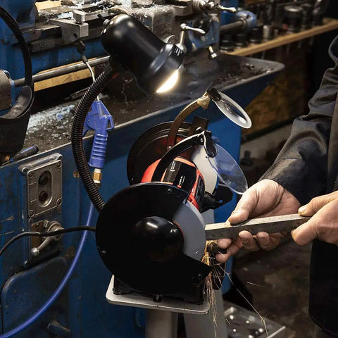 Powerful Eight Inch Bench Grinder Boots Kickin Three Quarter Horsepower Motor used for cutting metal with sparks and on-board work lamp.